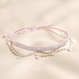 Full Picture of Estella Bartlett Set of 2 Pink and Silver Bracelets on beige fabric