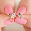Model with pink nails holding the Estella Bartlett Asymmetric Multicolour Crystal Stud Earrings