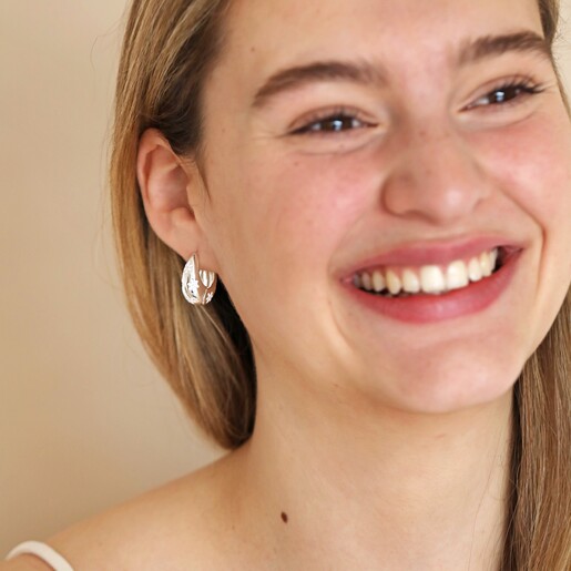Estella Bartlett Chunky Flower Dome Hoops in Silver on Smiling Model