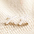 Estella Bartlett Kiss Stud Earrings In Silver on Beige Fabric
