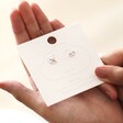 Estella Bartlett Kiss Stud Earrings In Silver on Packaging Card in Model's Hand