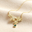 Estella Bartlett Green Crystal Floral Bee Pendant Necklace in Gold on top of beige coloured fabric