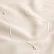 Full Estella Bartlett Kiss Pendant Necklace in Silver on Beige Fabric 