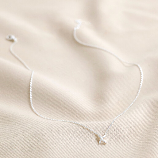 Full Estella Bartlett Kiss Pendant Necklace in Silver on Beige Fabric 