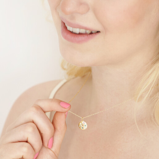 Estella Bartlett Multicoloured Crystal Disc Pendant in Gold Worn by Model, Holding Pendant Up