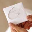 Estella Bartlett Triple Disc Charm Necklace In Silver in Packaging Held by Model