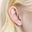Close Up of Sterling Silver Tiny Bow Stud Earrings on Model