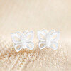 Sterling Silver Tiny Butterfly Stud Earrings on Beige Fabric