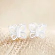 Sterling Silver Tiny Butterfly Stud Earrings on Beige Fabric