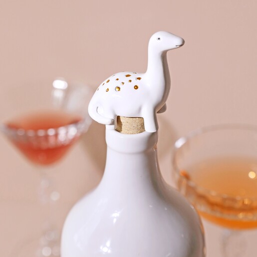 Diplodocus Dinosaur Bottle Stopper in White Bottle with Drinks in Background