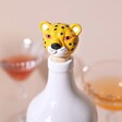 Leopard Head Bottle Stopper in White Bottle with Drinks in the Background