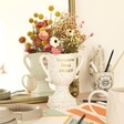 Personalised Ceramic Speckled Trophy with gold personalisation in lifestyle shot with flowers inside