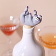 Sloth Bottle Stopper in White Bottle with Drinks in Background