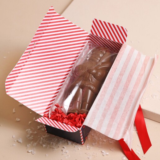 The Chocolate Gift Company Hollow Milk Chocolate Santa in packaging open against cream surface with fake snow