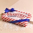 The Chocolate Gift Company Naughty Chocolate Elves Box on top of beige backdrop with fake snow