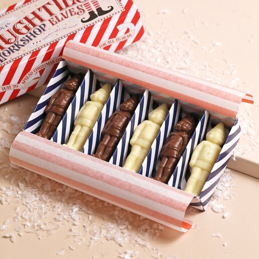 The Chocolate Gift Company Naughty Chocolate Elves Box open with chocolate elves inside on beige surface