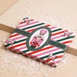 The Chocolate Gift Company Nutcracker Hazelnut Chocolate Bar on top of raised beige surface with fake snow