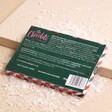 Back of The Chocolate Gift Company Nutcracker Hazelnut Chocolate Bar on top of beige surface with fake snow 