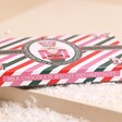 Side of The Chocolate Gift Company Nutcracker Hazelnut Chocolate Bar on top of beige surface with fake snow