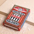 The Chocolate Gift Company Chocolate Toy Soldiers on top of neutral surface with fake snow