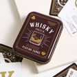 Gentlemen's Hardware Whisky Playing Cards in Closed Tin on White Surface with Scattered Cards