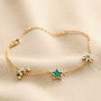 Green Enamel Star Sun and Moon Charm Bracelet in Gold on Beige Fabric