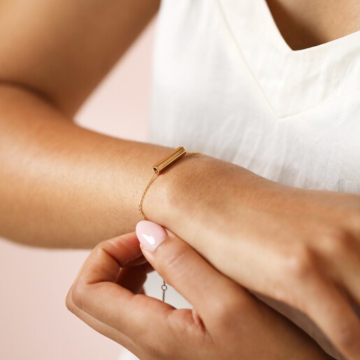 Model Putting on Hexagonal Barrel Charm Bracelet in Gold