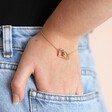 Model Wearing Interlocking Crystal Heart Bracelet in Gold With Hand in Pocket