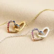 Interlocking Rainbow Crystal Heart Bracelet in Silver with gold version on beige coloured fabric