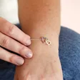 Model wearing Interlocking Rainbow Crystal Heart Bracelet in Silver with hand on wrist