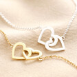 Interlocking Heart Charm Bracelets in Silver and Gold on Beige Fabric