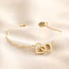 Interlocking Heart Charm Bracelet in Gold on beige fabric