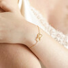 Model Wearing Interlocking Heart Charm Bracelet in Gold