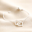 Interlocking Heart Charm Bracelet in Silver on Beige Fabric