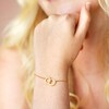 Close Up of Model Wearing Interlocking Matte Hoops Bracelet in Gold