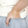 Model Wearing Interlocking Pearl and Crystal Hoops Bracelet in Gold With Hand in Pocket
