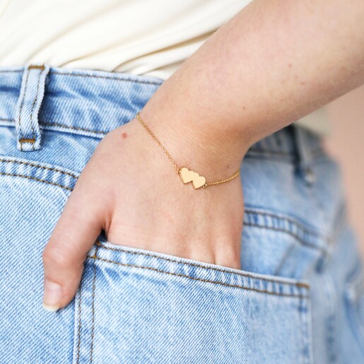 Linked Solid Hearts Charm Bracelet in Gold on model with hand in jean pocket