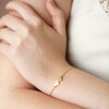 Model wearing Linked Solid Hearts Charm Bracelet in Gold with hand on arm