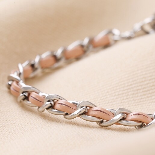 Close Up of Stainless Steel Pink Vegan Leather Twisted Bracelet  on Beige Fabric