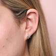 Close up of Crystal Snake Huggie Hoop Earrings in Gold on model