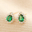 Gold Sterling Silver Green Teardrop Crystal Stud Earrings on Beige fabric