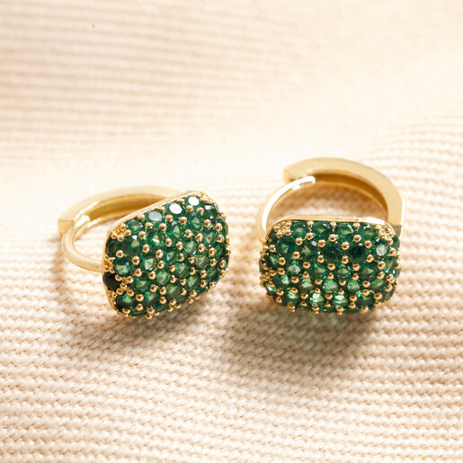 Green Crystal Pavé Square Huggie Hoop Earrings in Gold on top of beige coloured fabric