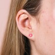 Close up of Pink Enamel Daisy Stud Earrings in Silver on model against beige backdrop
