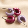 Lilac and Purple Domed Resin Hoop Earrings on Beige Fabric