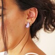 Close Up of Purple Resin Domed Huggie Hoop Earrings in Curated Ear Stack