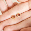 Red Stone Heart Stud Earrings in Gold Held by Model