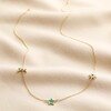 Green Enamel Star Sun and Moon Charm Necklace in Gold full length on neutral coloured fabric