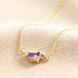 February Birthstone Cluster Necklace in Gold on Beige Fabric