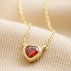 Red Stone Heart Pendant Necklace in Gold on neutral coloured fabric