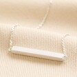 Horizontal Bar Necklace in Silver on top of beige coloured fabric